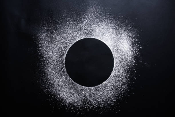 istock Abstract background. Sprinkled wheat flour circle, round spot on black. Top view on blackboard. Baking concept, cooking dough or pastry. 1310753171