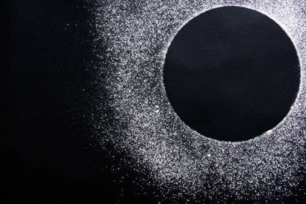 istock Abstract background. Sprinkled wheat flour circle, round spot on black. Top view on blackboard. Baking concept, cooking dough or pastry. 1310753410