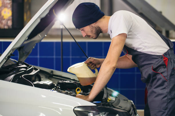 istock Auto mechanic is changing motor oil into a engine 1310754053