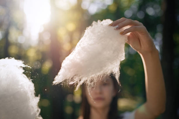 istock Girl eating cotton candy at park 1310754311