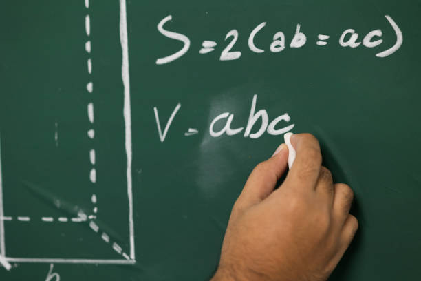 istock Education background concept. Close up male hand writing mathematical formula on chalkboard. 1310754454