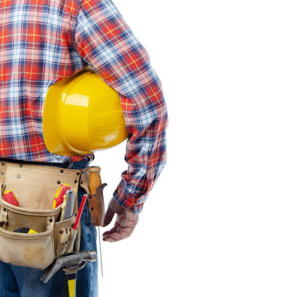 istock Middle aged caucasian contractor with tool belt holds yellow hard hat under his hand on white background 1310756781