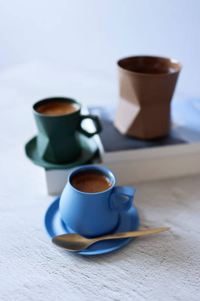 istock Sparkling Turkish coffee in a blue and green ceramic cup on a light gray concrete floor, Front view 1310757269
