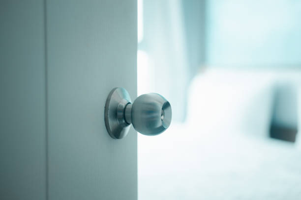 istock White door with handle opening through bedroom. Door half opened on blurred bedroom background. Selective focus. 1310758513