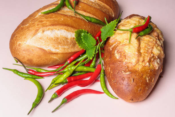 Fresh bread on the table with red and green chili peppers.