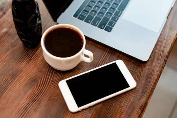 istock Workspace with coffee, laptop and smartphone on wooden table 1310760829