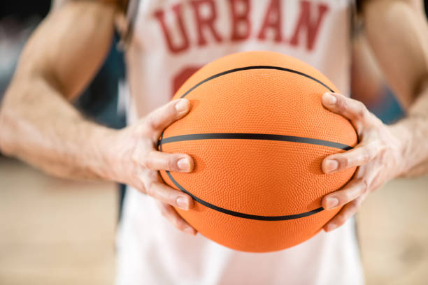istock Man holding a big orange ball in hands 1310761848