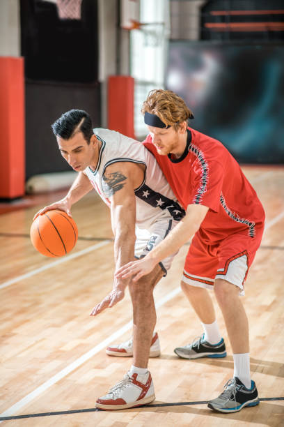 istock Two young men playing basketball and looking excited 1310761927