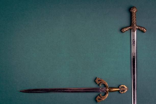 istock Two old knightly swords on a green velvet background. 1310762074