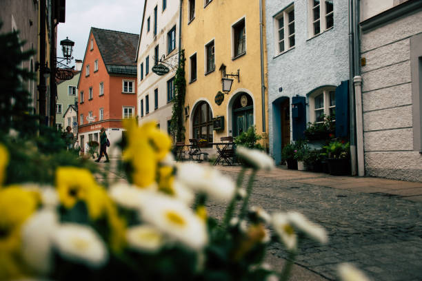 Fussen, gorgeous atnopsheric flowers on the foreground Füssen, Germany 26 May 2019  - Historic fairy tale street in the village of Fussen fussen stock pictures, royalty-free photos & images