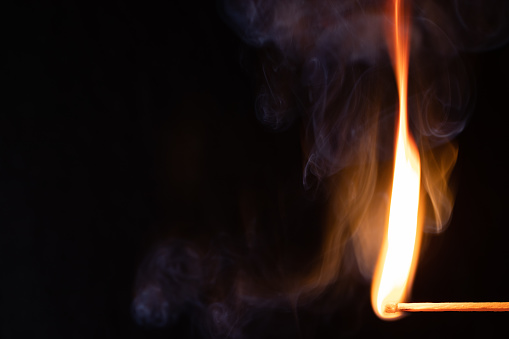 Macro shot of a burning match. Studio shot isolated on black background. Texture, Wallpaper