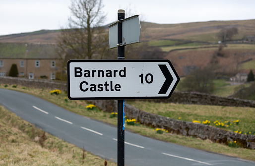 Barnard Castle signpost.  Black and white  10 miles sign, pointing right. Arkengarthdale, Yorkshire Dales. UK. Horizontal.  Space for copy.
