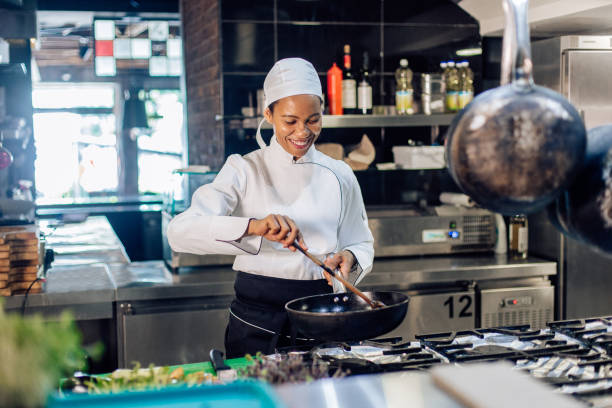 kobieta kucharz gotowania w restauracji - chef restaurant cooking african descent zdjęcia i obrazy z banku zdjęć