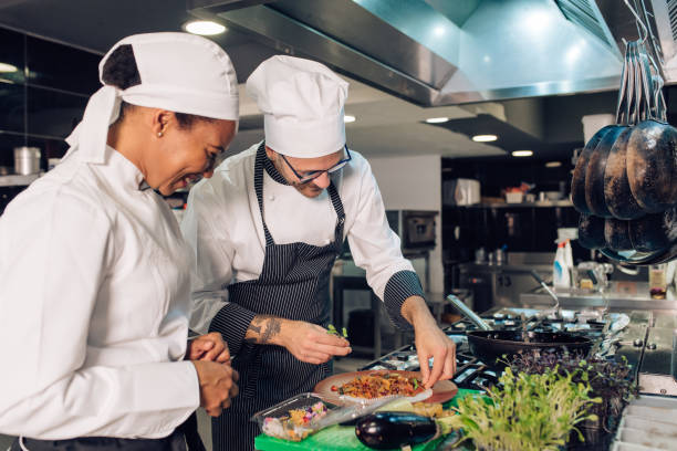 istock Young cooker making a fine dish with her chef 1310767766