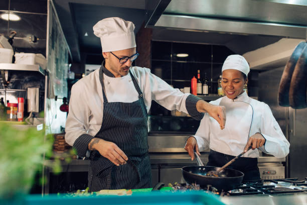 istock Chef showing to his trainee how to spice a dish 1310767769