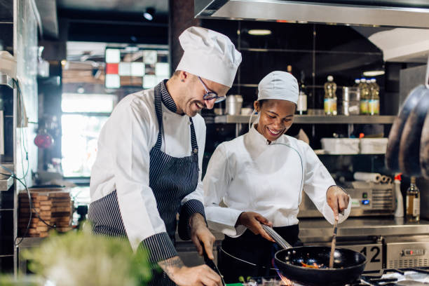 istock Young cooker enjoying cooking with chef 1310768275