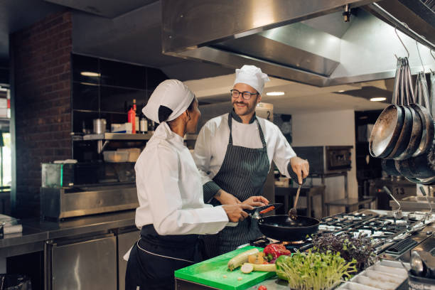 istock Chef and his trainee cooking together 1310768286