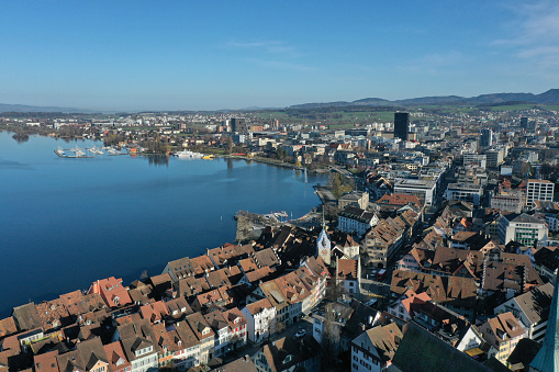 Zug City with the medieval old town and the church. The wide angle image with focus on the old town and the lake zug was captured during springtime.