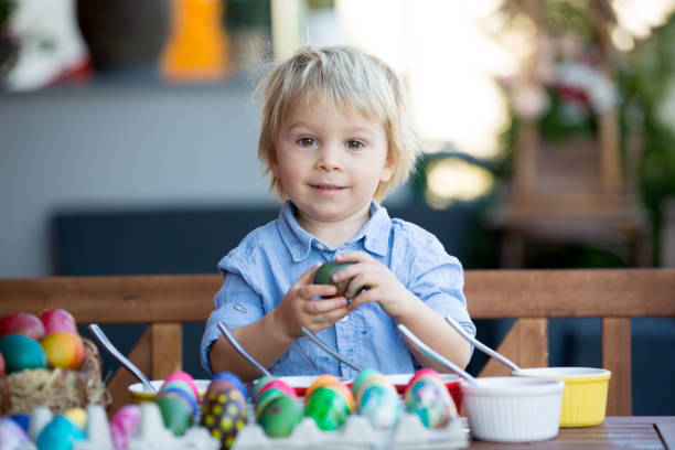 庭でイースターのための甘い子供、兄弟、着色と絵画の卵、裏庭の自宅で屋外 - playground cute baby blue ストックフォトと画像