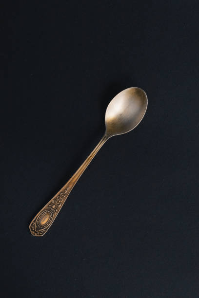 istock Old silver teaspoon on a black background. Vintage. Grunge. 1310770060