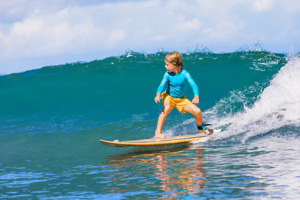 istock Young surfer learn to ride on surfboard on sea waves 1310771119
