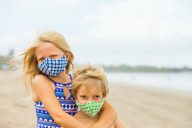 istock Children in face masks have fun on sea beach 1310771830