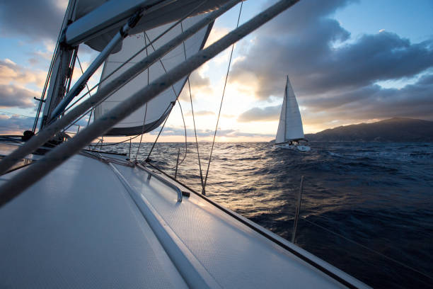 istock Sailing at sunrise. Two sailing yachts are sailing at dawn. 1310771834