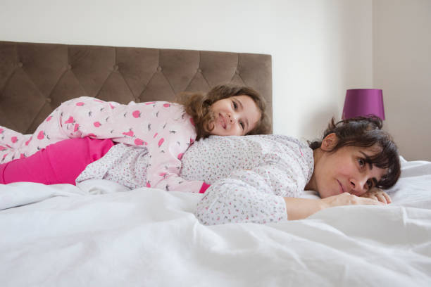 istock Mother and daughter lying in bed 1310771882