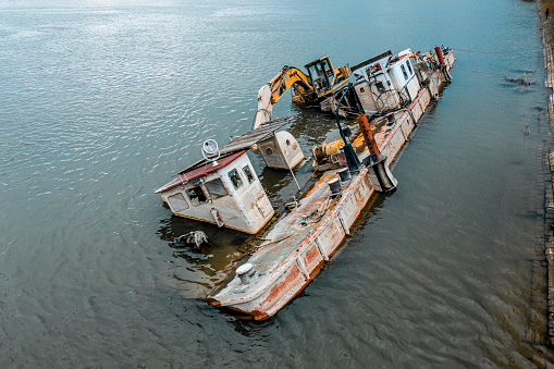 Aerial view of the barge seen half above and half underwater on the Danube river.