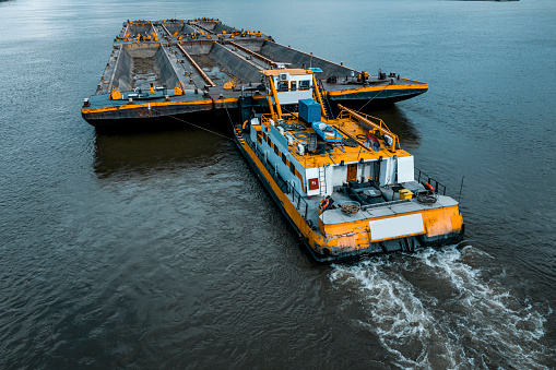 Vista aérea del remolcador empujando una barcaza pesada photo