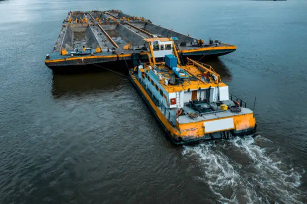 Top view of Tugboat pushing a heavy barge on the Danube river.