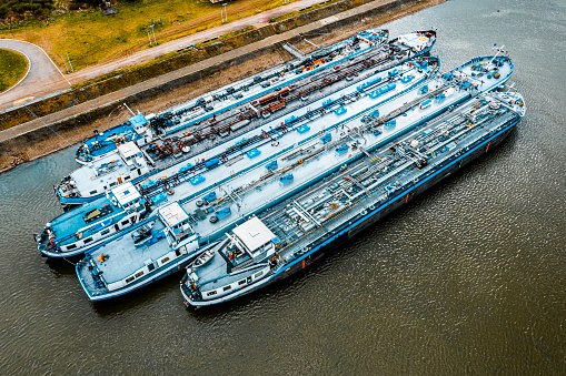 Loading grain into holds of sea cargo vessel in seaport from silos of grain storage. Bunkering of dry cargo ship with grain. Aerial top view.