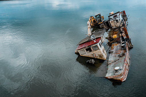 Aerial view of the ship wreck half above and half underwater on the Danube river.