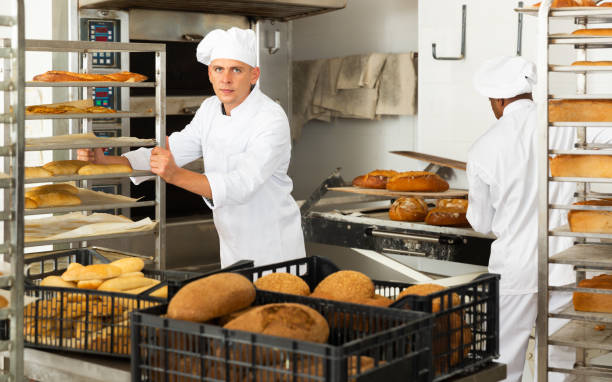istock male baker with bread in baking shovel and cart in kitchen 1310774431