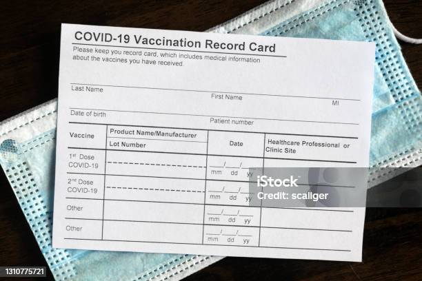 Covid19 Vaccination Record Card On Desk Stock Photo - Download Image Now - Immunization Certificate, Vaccination, COVID-19 Vaccine