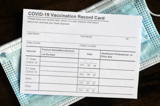 Photo of COVID-19 Vaccination Record Card on desk