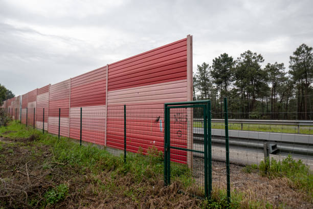 Orange noise protection wall on a freeway. Highway noise barrier stock photo