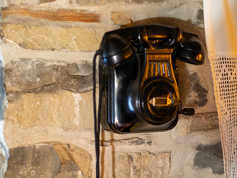old black phone, vintage rotary phone hanging on the wall