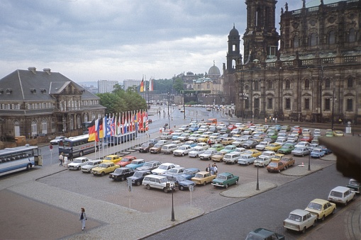 Dresden, Saxony, Germany (East), 1990. Parking lot in front of the Dresden Opera. Aso: tourists, cars, buses and buildings.