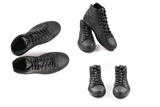 istock men's black leather shoes and a black camera on a black background. Copy space. 1310780764