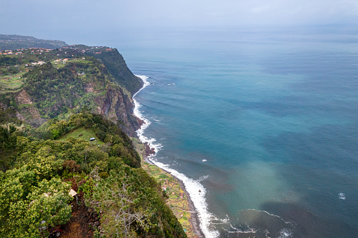 Aerial view of the North coast of the island of Madeira, in the area of the village Santana. At the shoreline there are agricultural fields, this places are called \