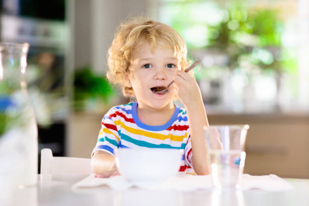 istock Child eating breakfast. Kid with milk and cereal. 1310784408