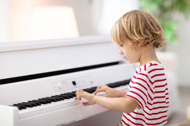 istock Child playing piano. Kids play music. 1310784512