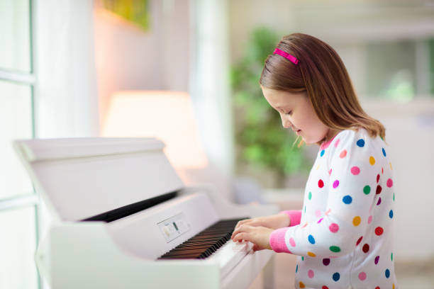 istock Child playing piano. Kids play music. 1310784702