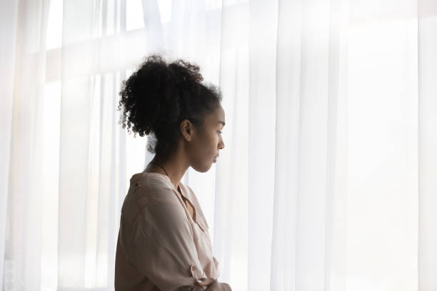 mujer afroamericana pensante mira a distancia pensando - barred windows fotografías e imágenes de stock