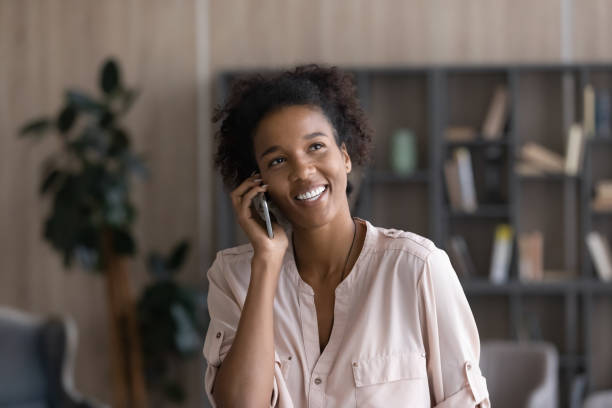 istock Smiling biracial woman talk on cellphone gadget 1310784989