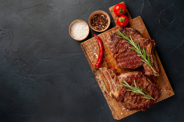 istock Beef steak, herbs and spices on a stone background with copy space for your text 1310786002