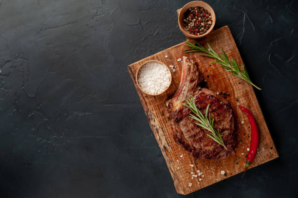 istock Beef steak, herbs and spices on a stone background with copy space for your text 1310786069