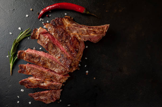 istock Beef steak, herbs and spices on a stone background with copy space for your text 1310786089