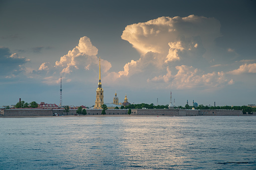 Russia, St.Petersburg, 09 June 2020: Improbable landscape on the Neva River at sunset, a gold spike of the Peter and Paul Fortress, improbable clouds. High quality photo